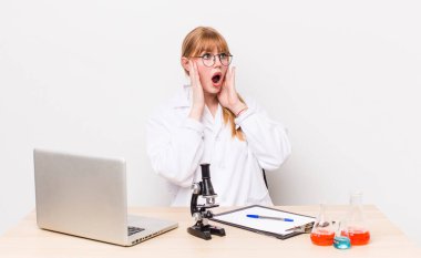 Kızıl saçlı güzel kadın mutlu, heyecanlı ve şaşırmış hissediyor. Mikroskobik bilim adamı.