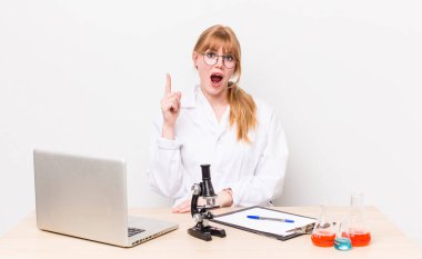 Kızıl saçlı, güzel bir kadın bir fikri fark ettikten sonra mutlu ve heyecanlı bir dahi gibi hissediyor. Mikroskobik bilim adamı.