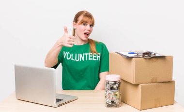 Kızıl saçlı güzel bir kadın gururlu, olumlu gülümsüyor. Bağış gönüllüsü konsepti