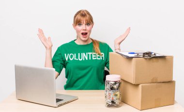 Kızıl saçlı güzel kadın kendini mutlu hissediyor ve inanılmaz bir şeye hayret ediyor. Bağış gönüllüsü konsepti