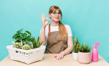 Kızıl saçlı güzel bir kadın kendini mutlu hissediyor. Onayını iyi bir hareketle gösteriyor. bitkiler gargara konsepti