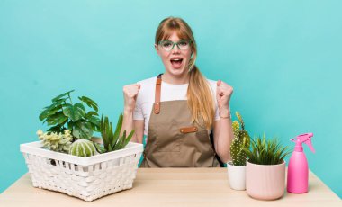 Kızıl saçlı güzel kadın şok olmuş hissediyor, gülüyor ve başarıyı kutluyor. bitkiler gargara konsepti