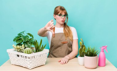 Kızıl saçlı, güzel bir kadın kendini kötü hissediyor, baş parmağını kaldırıyor. bitkiler gargara konsepti