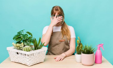 Kızıl saçlı güzel bir kadın şok olmuş, korkmuş ya da korkmuş görünüyor. bitkiler gargara konsepti