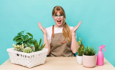 Kızıl saçlı güzel kadın kendini mutlu hissediyor ve inanılmaz bir şeye hayret ediyor. bitkiler gargara konsepti
