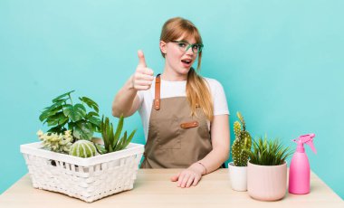 Kızıl saçlı güzel bir kadın gururlu, olumlu gülümsüyor. bitkiler gargara konsepti