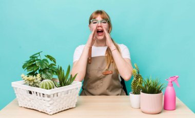 Kızıl saçlı, güzel bir kadın kendini mutlu hissediyordu. Elleri ağzının kenarında bağırıyordu. bitkiler gargara konsepti