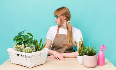 Profil bakışlı kızıl saçlı güzel kadın hayal mi kuruyor yoksa hayal mi kuruyor? bitkiler gargara konsepti