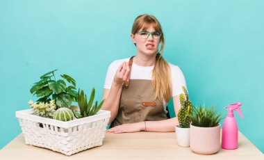 Kızıl saçlı, güzel bir kadın kapiş ya da para hareketi yapıyor, sana ödemeni söylüyor. bitkiler gargara konsepti