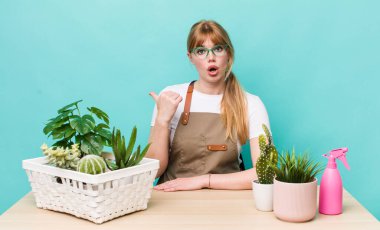 Kızıl saçlı, güzel bir kadın inançsızlıktan şaşkın şaşkın bakıyor. bitkiler gargara konsepti