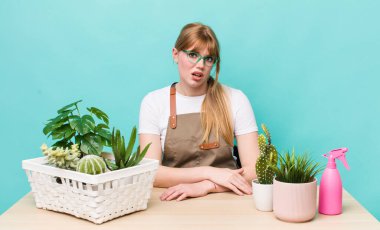 Kızıl saçlı güzel kadın şaşkın ve şaşkın hissediyor. bitkiler gargara konsepti