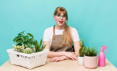 Kızıl saçlı güzel kadın mutlu ve hoş bir şekilde şaşırmış görünüyor. bitkiler gargara konsepti