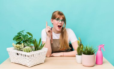 Kızıl saçlı, güzel bir kadın bir fikri fark ettikten sonra mutlu ve heyecanlı bir dahi gibi hissediyor. bitkiler gargara konsepti