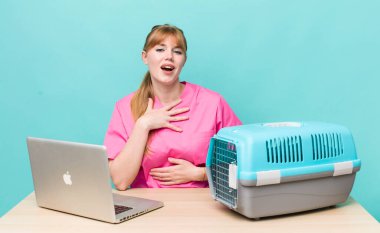 Kızıl saçlı güzel bir kadın komik bir şakaya yüksek sesle gülüyor. Veterinerlik kavramı