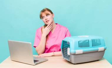 Kızıl saçlı, güzel bir kadın mutlu, kendinden emin, elleri çenesinde gülümsüyor. Veterinerlik kavramı