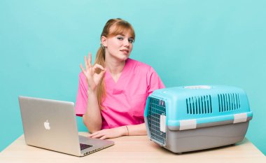 Kızıl saçlı güzel bir kadın kendini mutlu hissediyor. Onayını iyi bir hareketle gösteriyor. Veterinerlik kavramı