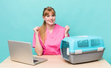 Kızıl saçlı güzel kadın şok olmuş hissediyor, gülüyor ve başarıyı kutluyor. Veterinerlik kavramı