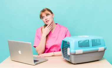 Kızıl saçlı, güzel bir kadın mutlu, kendinden emin, elleri çenesinde gülümsüyor. Veterinerlik kavramı