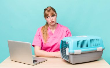 Kızıl saçlı, güzel bir kadın üzgün, üzgün ya da kızgın ve yana bakıyor. Veterinerlik kavramı