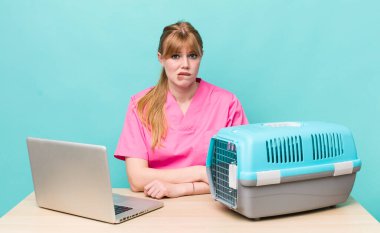 Kızıl saçlı güzel kadın kafası karışık ve şaşkın görünüyor. Veterinerlik kavramı