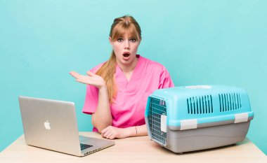 Kızıl saçlı, güzel bir kadın şaşırmış ve şok olmuş görünüyor. Çenesi düşmüş, elinde bir nesne var. Veterinerlik kavramı