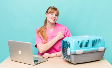 Kızıl saçlı güzel bir kadın kendini mutlu hissediyor ve bir meydan okumayla yüzleşiyor ya da kutluyor. Veterinerlik kavramı