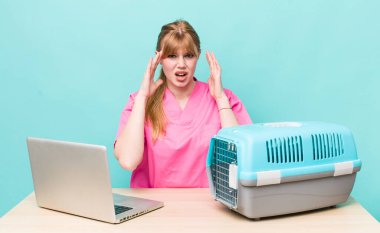 Kızıl saçlı güzel kadın ellerini havaya kaldırarak çığlık atıyor. Veterinerlik kavramı