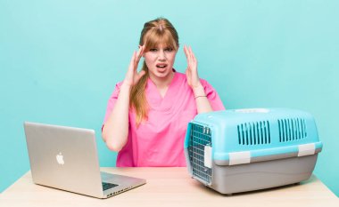 Kızıl saçlı güzel kadın ellerini havaya kaldırarak çığlık atıyor. Veterinerlik kavramı