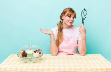 Kızıl saçlı güzel kadın şaşkın, şaşkın ve şüpheci hissediyor. Ev yapımı kek konsepti