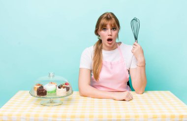 Kızıl saçlı güzel kadın çok şaşırmış ya da şaşkın görünüyor. Ev yapımı kek konsepti