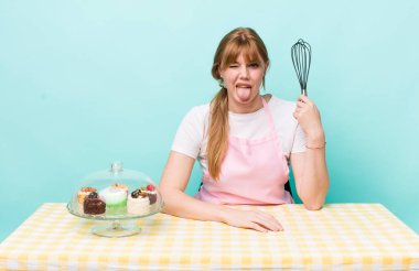 Kızıl saçlı, güzel, neşeli ve asi tavırlı, şaka yapan ve dilini dışarı çıkaran bir kadın. Ev yapımı kek konsepti