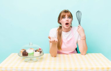 Kızıl saçlı güzel kadın çok şaşırmış ve şok olmuş hissediyor. Ev yapımı kek konsepti