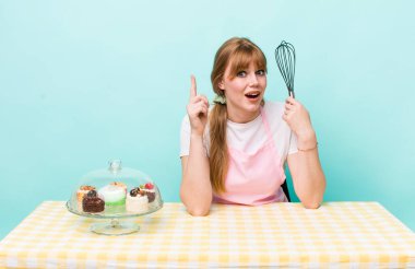 Kızıl saçlı, güzel bir kadın bir fikri fark ettikten sonra mutlu ve heyecanlı bir dahi gibi hissediyor. Ev yapımı kek konsepti