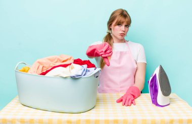 Kızıl saçlı, güzel bir kadın kendini kötü hissediyor, baş parmağını kaldırıyor. Demir giysi konsepti