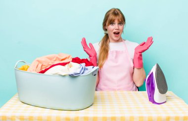 Kızıl saçlı güzel kadın kendini mutlu hissediyor ve inanılmaz bir şeye hayret ediyor. Demir giysi konsepti