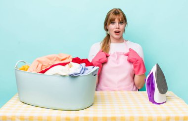 Kızıl saçlı güzel bir kadın mutlu hissediyor ve heyecanla kendini işaret ediyor. Demir giysi konsepti