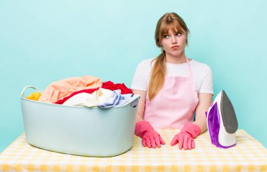 Kızıl saçlı, güzel bir kadın üzgün, üzgün ya da kızgın ve yana bakıyor. Demir giysi konsepti