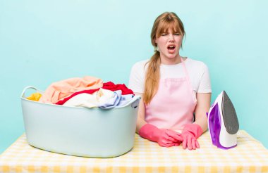 Kızıl saçlı, güzel bir kadın agresif bir şekilde bağırıyor, çok kızgın görünüyor. Demir giysi konsepti