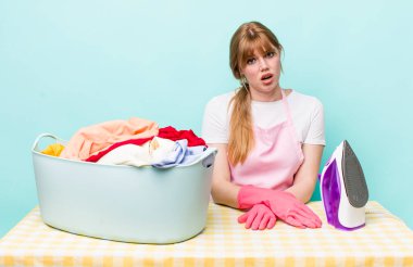 Kızıl saçlı güzel kadın şaşkın ve şaşkın hissediyor. Demir giysi konsepti