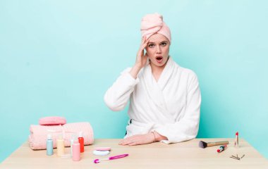 Kızıl saçlı güzel kadın mutlu, şaşkın ve şaşırmış görünüyor. duş ve kozmetik konsepti