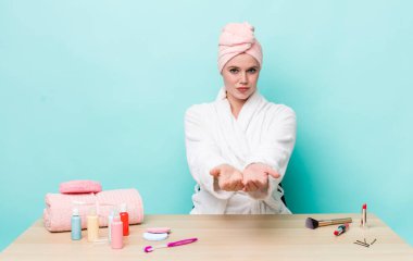 Kızıl saçlı, güzel bir kadın arkadaşça gülümsüyor ve bir konsept sunuyor. duş ve kozmetik konsepti