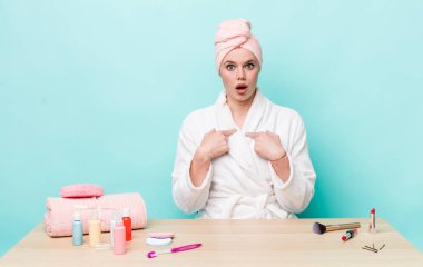 Kızıl saçlı güzel bir kadın mutlu hissediyor ve heyecanla kendini işaret ediyor. duş ve kozmetik konsepti