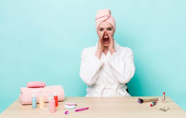 Kızıl saçlı, güzel bir kadın kendini mutlu hissediyordu. Elleri ağzının kenarında bağırıyordu. duş ve kozmetik konsepti