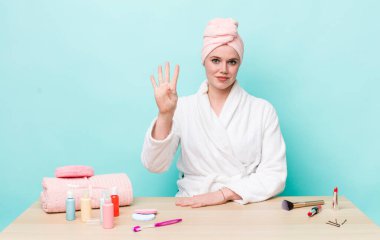 Kızıl saçlı güzel kadın gülümsüyor ve arkadaş canlısı görünüyor, dört numarayı gösteriyor. duş ve kozmetik konsepti