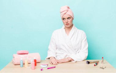 Kızıl saçlı, güzel bir kadın üzgün, üzgün ya da kızgın ve yana bakıyor. duş ve kozmetik konsepti