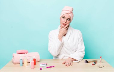 Kızıl saçlı güzel kadın düşünüyor, kuşkulu ve şaşkın hissediyor. duş ve kozmetik konsepti