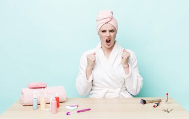 Kızıl saçlı güzel bir kadın sinirli bir ifadeyle agresif bir şekilde bağırıyor. duş ve kozmetik konsepti