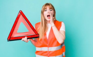 Kızıl saçlı, güzel bir kadın kendini mutlu hissediyordu. Elleri ağzının kenarında bağırıyordu. araba acil üçgeni