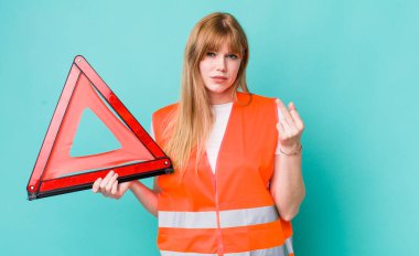 Kızıl saçlı güzel bir kadın kızgın, sinirli, asi ve agresif hissediyor. araba acil üçgeni