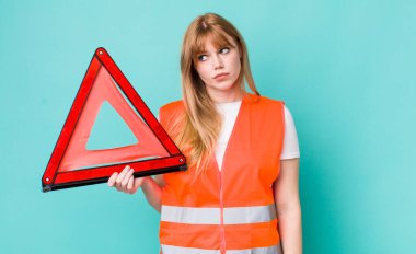 Kızıl saçlı, güzel bir kadın üzgün, üzgün ya da kızgın ve yana bakıyor. araba acil üçgeni